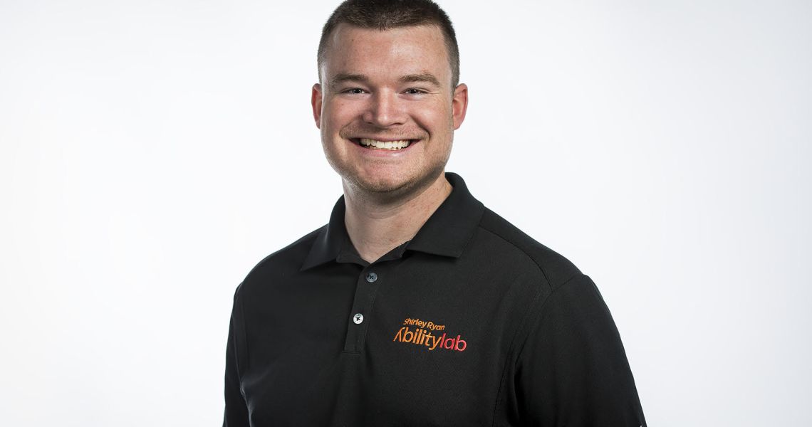 Man in black polo shirt smiling for camera