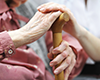 Close up of two sets of hands on a cane