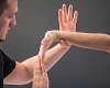 A physical therapist stretching someone's hand