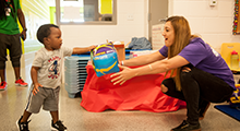 Toddler handing a Physical Therapist a toy