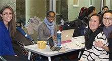 Students sitting around a table and smiling