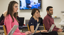 Students in a classroom looking at laptops