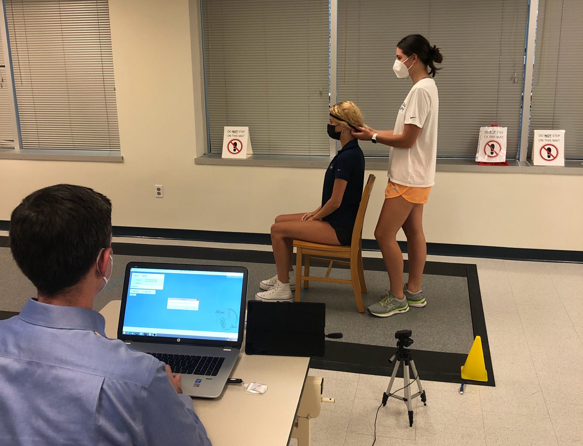 Student research assistants demonstrating use of IMU head band on pressure sensing mat