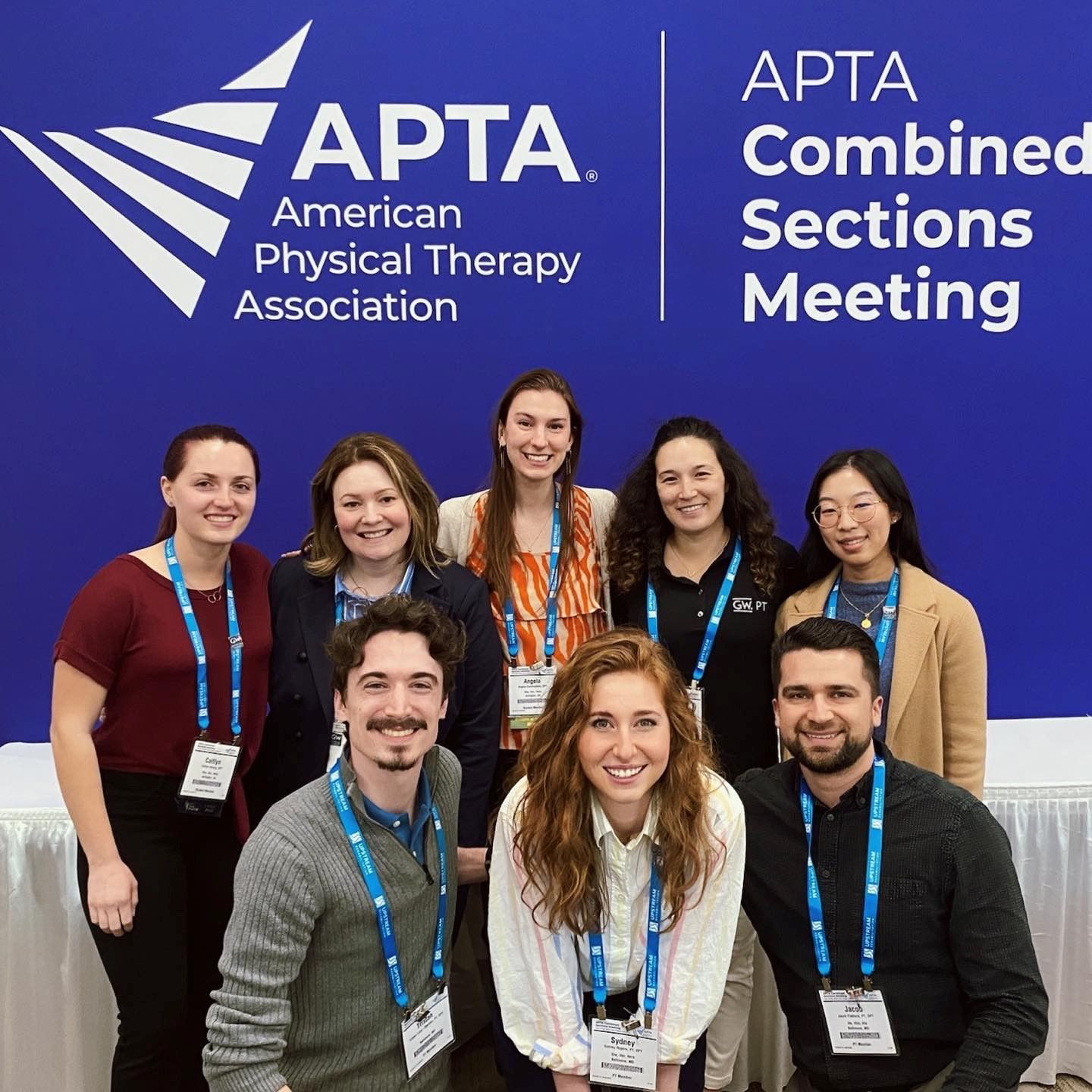 GW students and adjunct faculty pose in front of APTA CSM sign