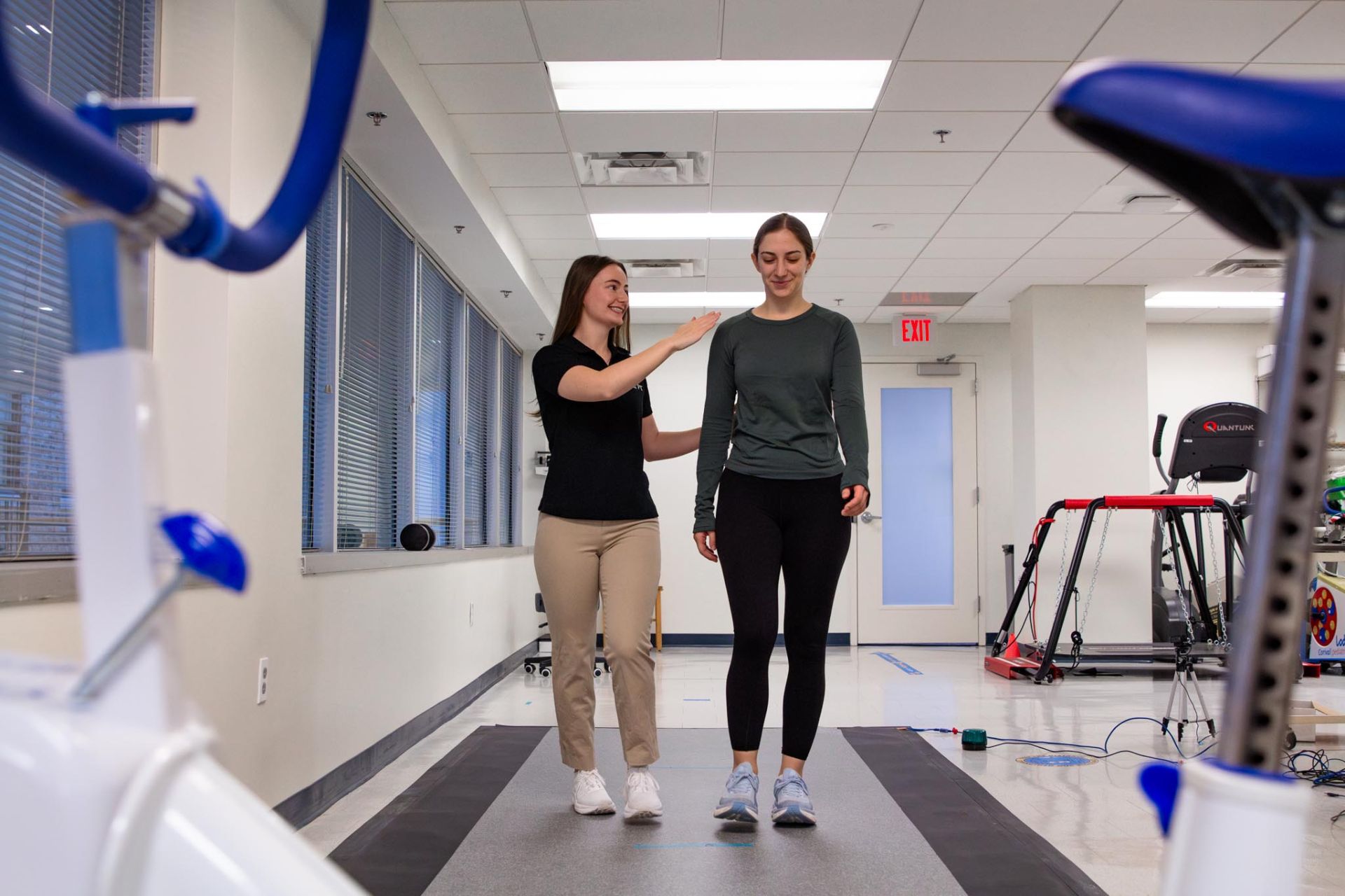 Participant and student research assistant walking across pressure sensitive mat