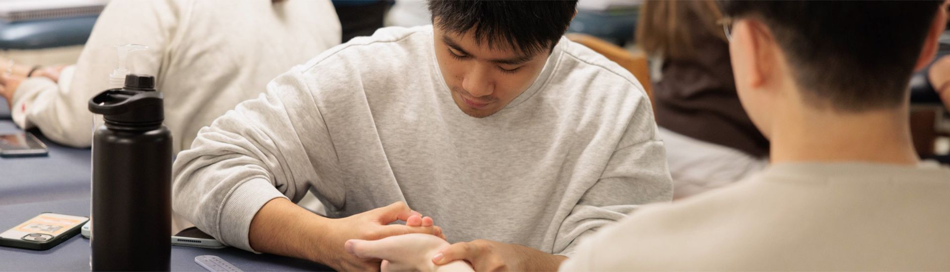 physical therapist assisting a patient with wrist exercises